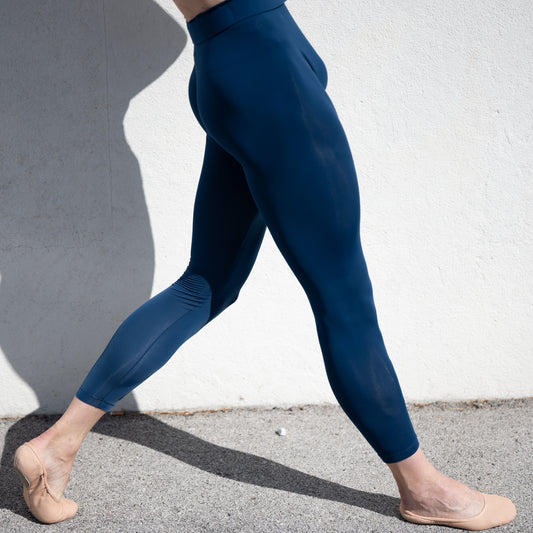 Denys Cherevychko wearing blue leggings against a white wall