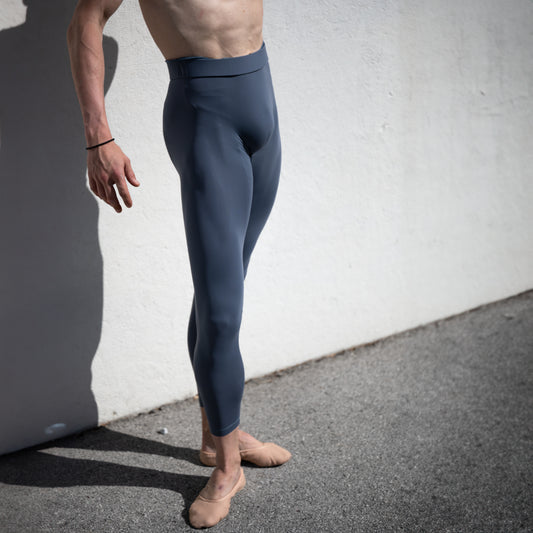 Denys Cherevychko wearing grey leggings against a white wall.