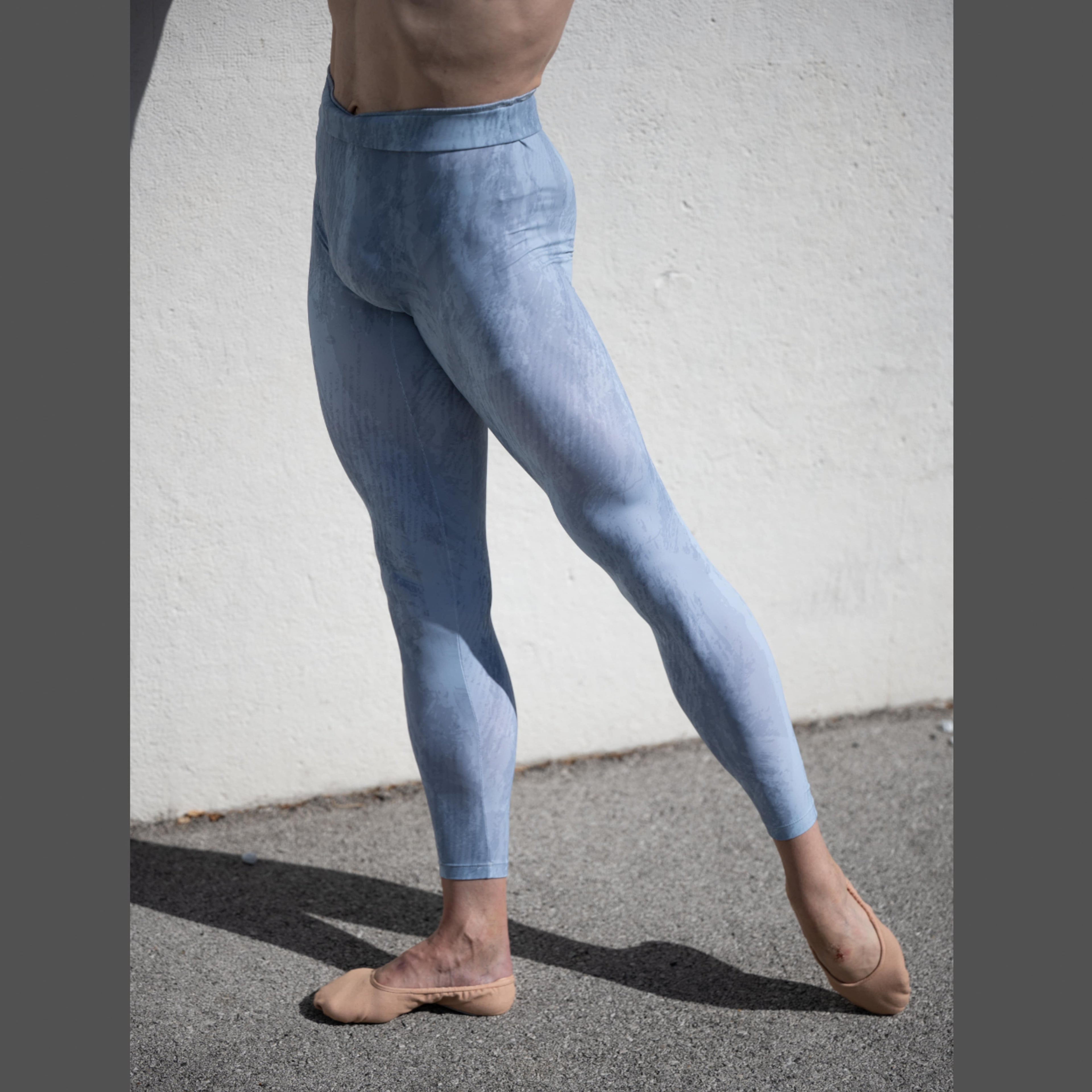 Denys Cherevychko wearing light blue leggings against a white wall.