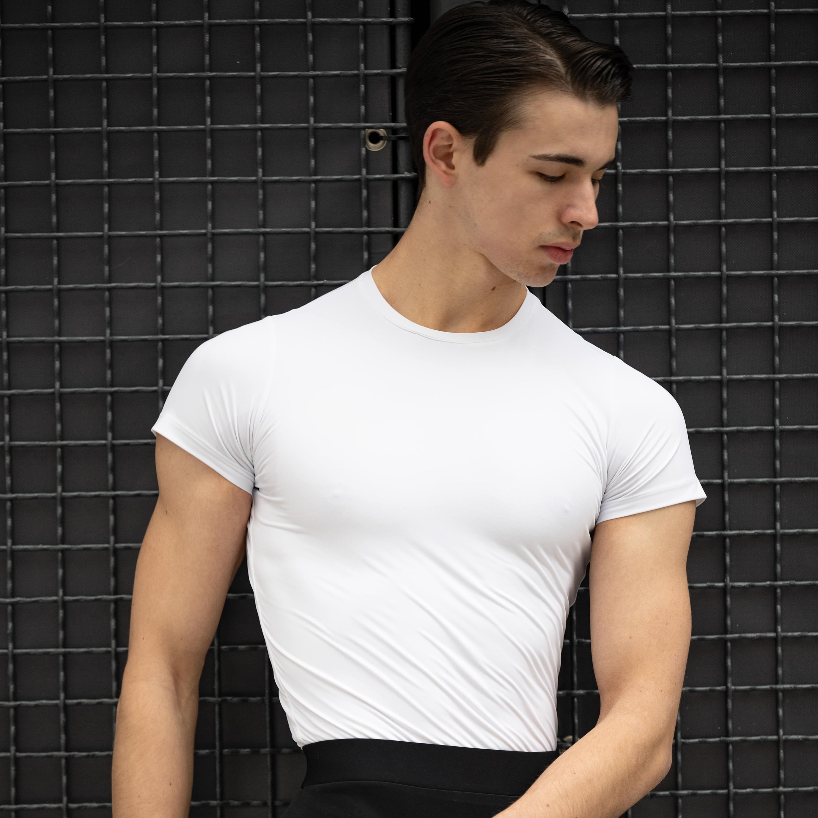 A male model wearing a white short sleeve t-shirt.